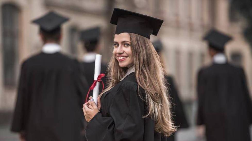 New graduate in robes holding diploma