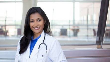 Smiling doctor standing near window in hospital