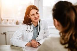 Smiling doctor discussing with a patient