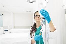 Healthcare worker checking fluids in drip line